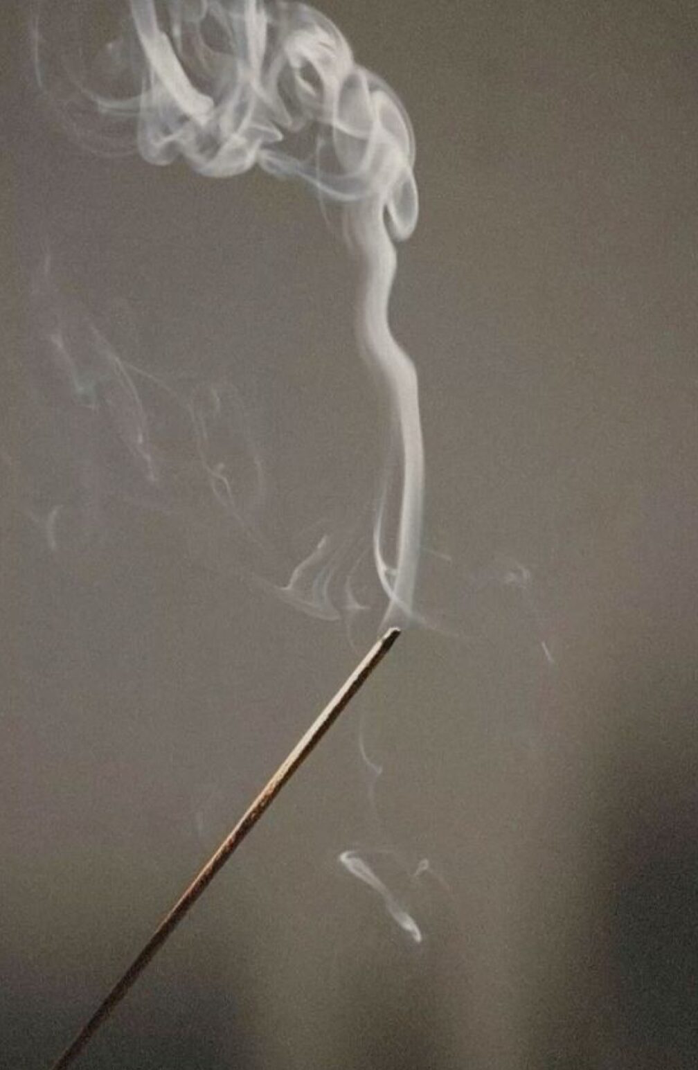Incense smoke rising in contemplative space representing transformation